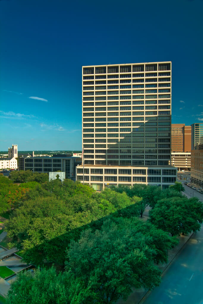 A large building with trees in the foreground.